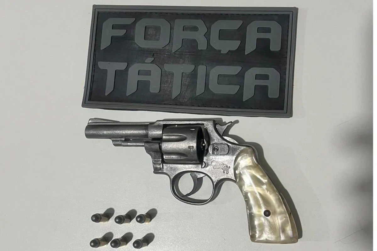 Arma em cima da mesa com escudo da Força Tática da Polícia Militar do Piauí